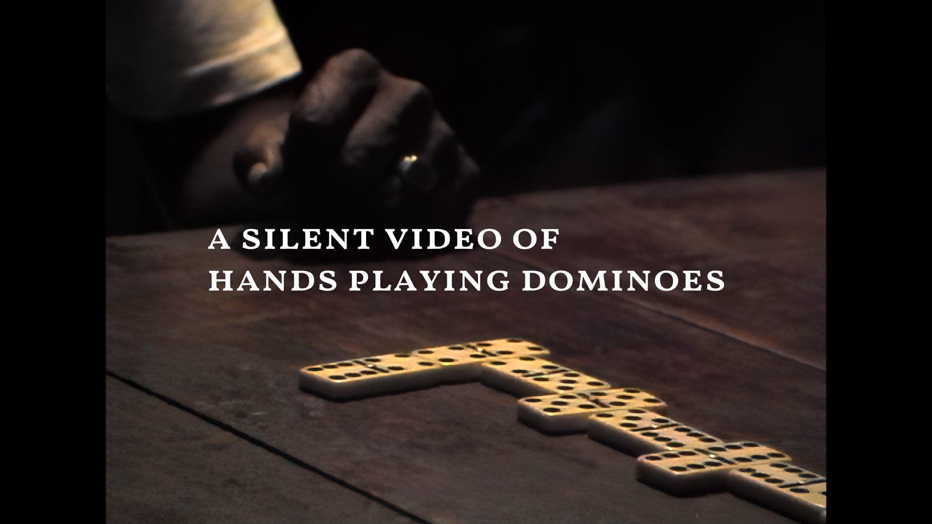 A silent video of hands playing dominoes